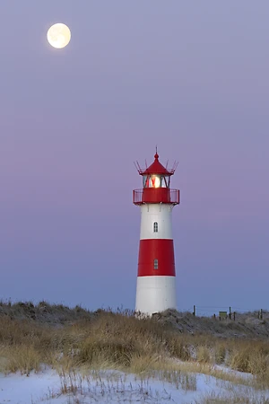 The red and white lighthouse of List Ost on the Ellenbogen peninsula, List with full moon, Sylt, North Frisia, Schleswig-Holstein, Germany